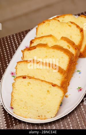 Un colpo verticale di fette di deliziosa torta di libbra su un piastra bianca Foto Stock