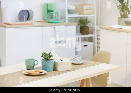 Immagine di biscotti e tazze di caffè o tè sul tavolo in legno in cucina Foto Stock