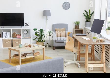 Immagine di un moderno soggiorno con TV e tavolo con computer in casa Foto Stock