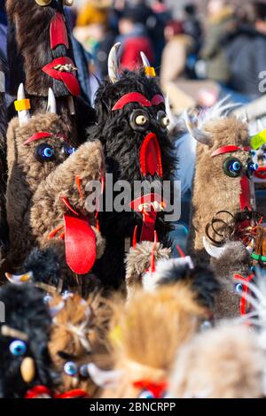 Le bambole Mummers eseguono rituali con costumi, volti a spaventare gli spiriti malvagi durante il festival internazionale dei giochi di mascherata Surva. Foto Stock