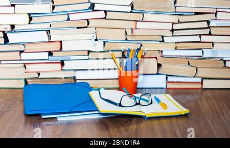 Apri libro di testo, taccuino, occhiali, matite nel contenitore, cartella di plastica, pila di libro. Home distanza formazione concetto di fondo, molti mucchi di libri con Foto Stock