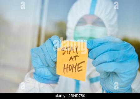 Messaggio Stay at Home sulla nota appiccicosa alla porta della clinica per coronavirus e pandemia Covid-19 Foto Stock