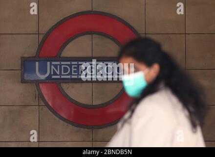 RITRASMESSO AGGIUNGENDO PAROLA CHIAVE E DETTAGLIO UNA donna che indossa una maschera facciale cammina oltre la stazione della metropolitana di Leicester Square a Londra. Il trasporto per Londra (TfL) sarà costretto a ridurre i servizi a meno che non riceva una sovvenzione del governo giovedì, ha dichiarato Sadiq Khan. Il sindaco di Londra ha affermato che senza un sostegno finanziario, l'ente dei trasporti deve tagliare le reti di autobus e metropolitana. Foto Stock