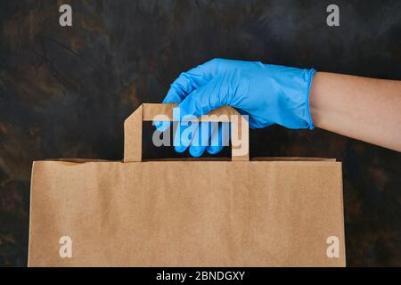 Scatola di donazione di cibo. Donna che consegna cibo in sacchetto di carta durante l'epidemia di Covid 19 Foto Stock