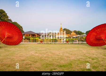 Bagan Myanmar - Ottobre 31 2013; luminoso rosso tradizionale ombrello s cornice di vista di Thiripyitsaya Sanctuary Resort edifici e terreni. Foto Stock