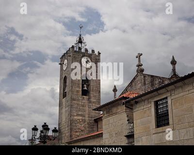 Antico campanile in granito della chiesa madre. Città medievale di Ponte de Lima, Portogallo settentrionale, in una giornata nuvolosa Foto Stock