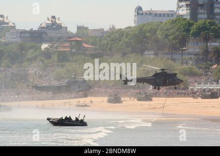 Serie 37 di 165 gommoni AAV-7A veicoli anfibi sulla spiaggia e Eurocopter AS332B1 Super Puma e Sikorsky SH-3 Sea King Armed Forces Day Foto Stock