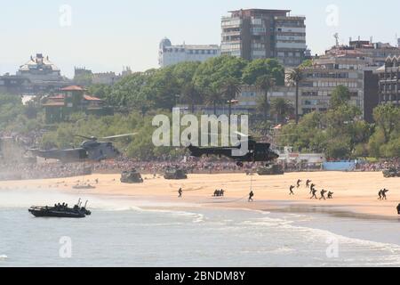 Serie 41 di 165 gommoni AAV-7A veicoli anfibi sulla spiaggia e Eurocopter AS332B1 Super Puma e Sikorsky SH-3 Sea King Armed Forces Day Foto Stock