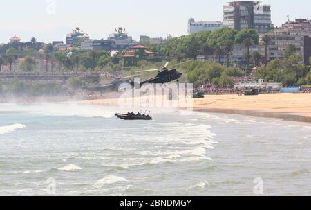 Serie 35 di 165 gommoni AAV-7A veicoli anfibi sulla spiaggia e Eurocopter AS332B1 Super Puma e Sikorsky SH-3 Sea King Armed Forces Day Foto Stock