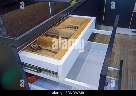 Arredamento di design interno della cucina in appartamento di lusso che mostra closeup dettaglio di armadio scorrevole con cassettiera in legno Foto Stock