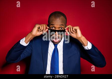 Closeup foto di bello attraente pelle scura business ragazzo che tegole occhiali da sole ascoltare sorprendente scioccante notizie indossare blu tuta in formalwear tuxedo Foto Stock