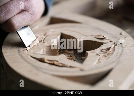 Primo piano della mano di un maestro irriconoscibile dell'intagliatore di legno sul lavoro. Foto Stock