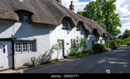 Fila di case in legno con tetto di paglia incorniciato nel Villaggio Hampshire di Wherwell, Test Valley, Hampshire, Inghilterra, Regno Unito. Foto Stock