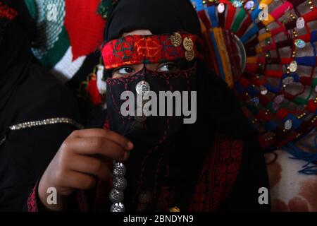 Khan Younis, Gaza. 14 maggio 2020.la profuga palestinese di dodici anni Hoda Amarna siede con i suoi familiari in abiti tradizionali, in commemorazione del 66° anniversario della 'Nakbaa', araba per 'catastrofe', termine usato per segnare gli eventi che hanno portato alla fondazione di Israele nel 1948, a Khan Yunis, Nella parte meridionale della striscia di Gaza, mercoledì 14 maggio 2020. Essi celebrano il 72° anniversario di 'Nakbaa' (giorno della catastrofe), mentre a casa a causa della pandemia del coronavirus COVID-19. Credit: UPI/Alamy Live News Foto Stock