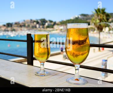 Le sue e le sue birre ghiacciate rinfrescanti in una giornata di sole che si affaccia sulla baia Foto Stock