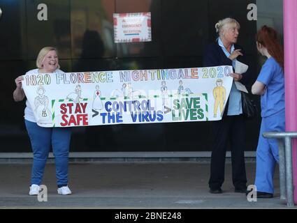 Il personale della NHS si riunisce fuori dall'Aintree University Hospital di Fazakerley, Liverpool, prima degli applausi per salutare gli eroi locali durante il Clap for Carers di giovedì per riconoscere e sostenere i lavoratori e gli assistenti della NHS che combattono la pandemia del coronavirus. Foto Stock