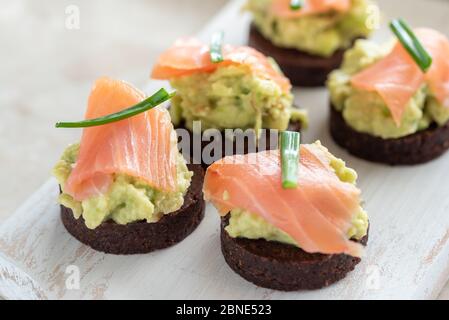 Pasta di avocado con salmone su pane integrale Foto Stock