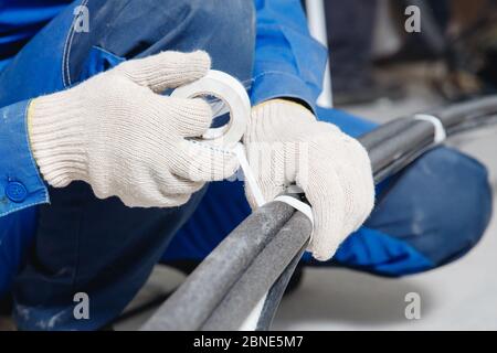 Worker man Installation of pipe channel for connecting air conditioner Foto Stock