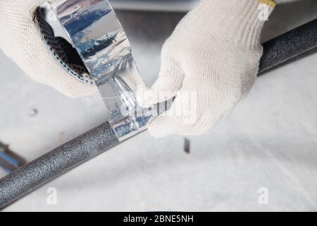 Worker man Installation of pipe channel for connecting air conditioner Foto Stock