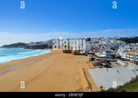 Persone che camminano nella primavera di sole sulla spiaggia di Albufeira in Portogallo Foto Stock