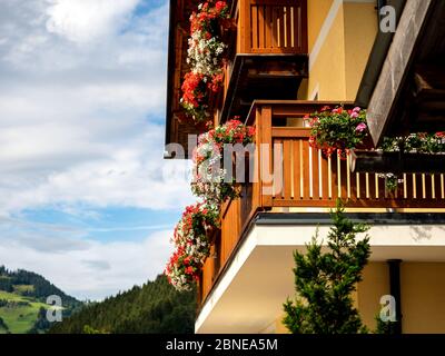 Balconi e terrazze decorate con fiori colorati in vaso in una località alpina in Austria. Grossarl. Foto Stock