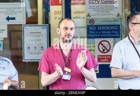 Eastbourne District General Hospital, East Sussex, Regno Unito. 14 maggio 2020. Giovedì alle 20:00, il personale e i visitatori si riuniscono fuori dall'ingresso per sostenere l'NHS durante l'epidemia di Covid 19. Come applaudito il presente, una flotta di veicoli pesanti ha guidato lungo la strada vicina suonando klaxons e corna in apprezzamento di tutti coloro che lavorano in questo trafficato ospedale della costa del Sud . Credit Alan Fraser/Alamy Live News Foto Stock