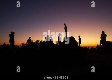 silhouette di persone che guardano il tramonto dalla cima della testa dei leoni, città del capo, sud africa Foto Stock