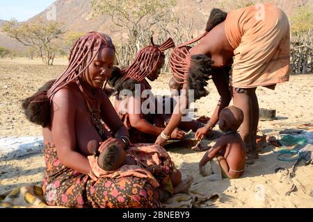 Donne e bambini di Himba, la valle di Marienfuss, il deserto di Kaokoland, Namibia. Ottobre 2015 Foto Stock