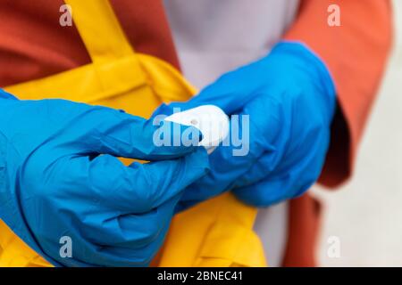 La mano della donna tira fuori antisettico dalla borsa Foto Stock