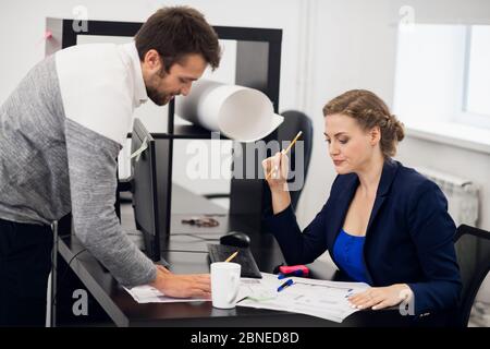 Una donna d'affari che ascolta il suo dipendente, non è soddisfatta w Foto Stock