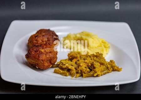 primo piano polpette, purè e patate di fagioli verdi in piatto Foto Stock