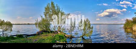 Vista panoramica sull'idilliaco paesaggio lacustre sul lago Schwerin con cielo blu e nuvole sullo sfondo. Foto Stock