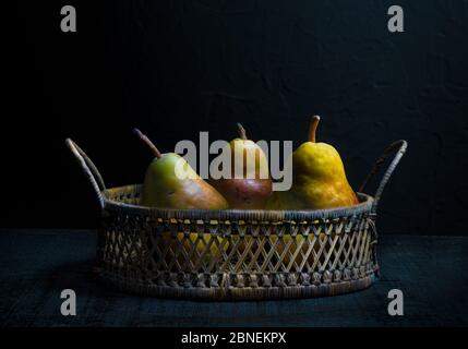 Tre pere mature in un cestino Foto Stock