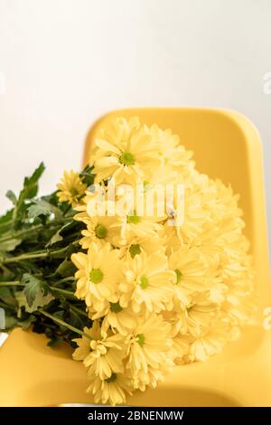 Fiori, vacanze, congratulazioni, concetto d'amore - bouquet grande luminoso di margherite gialle su sfondo grigio Foto Stock