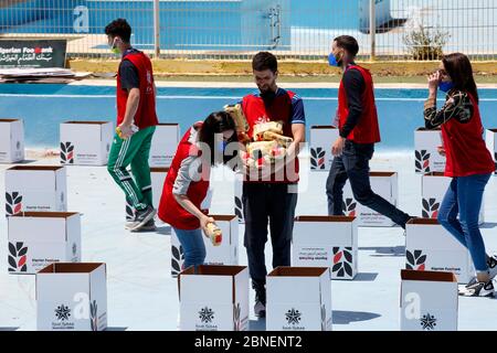 Algeri. 14 maggio 2020. Gli studenti volontari riempiono scatole con prodotti alimentari da distribuire alle famiglie bisognose ad Algeri, capitale dell'Algeria, il 14 maggio 2020. Le autorità algerine hanno esteso le regole di blocco parziale a livello nazionale fino al maggio 31, come parte degli sforzi per contenere la malattia, tra infezioni crescenti e decessi. Credit: Xinhua/Alamy Live News Foto Stock