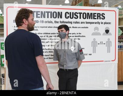 Mount Pleasant, Wisconsin, Stati Uniti. 14 maggio 2020. Una guardia di sicurezza applica la regola al negozio di miglioramento casa Menard nel villaggio di Mount Pleasant, Wisconsin Giovedi 14 maggio 2020 che tutti i clienti, compreso questo, devono indossare maschere. I clienti senza maschere devono acquistarne uno presso il banco del servizio clienti. Questo uomo è stato sentito dire che avrebbe andare in un negozio concorrente. La catena Menard è stata aperta durante tutta la crisi del Coronavirus, ma ha recentemente iniziato a richiedere maschere. In Wisconsin c'è incertezza sui clienti circa la riapertura delle aziende durante il Coronavi Foto Stock