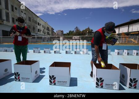 Algeri. 14 maggio 2020. Gli studenti volontari riempiono scatole con prodotti alimentari da distribuire alle famiglie bisognose ad Algeri, capitale dell'Algeria, il 14 maggio 2020. Le autorità algerine hanno esteso le regole di blocco parziale a livello nazionale fino al maggio 31, come parte degli sforzi per contenere la malattia, tra infezioni crescenti e decessi. Credit: Xinhua/Alamy Live News Foto Stock