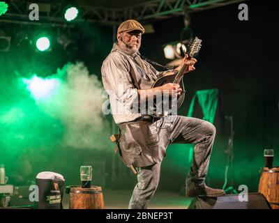 Una vista incredibile di un musicista divertente che dà una performance su un palcoscenico fumoso Foto Stock