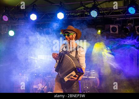 Una vista incredibile di un musicista divertente che dà una performance su un palcoscenico fumoso Foto Stock