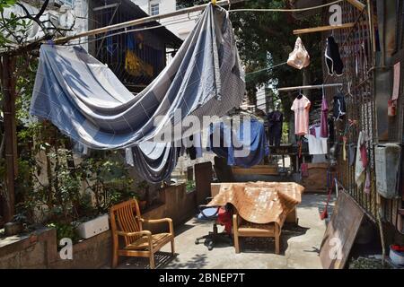 Vestiti appesi sotto il sole, all'aperto che si asciuga nel piccolo cortile della vecchia Guangzhou. Foto Stock