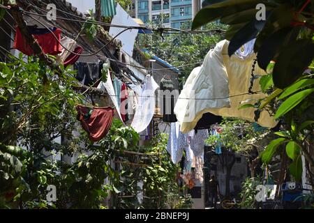 Vestiti appesi sotto il sole, all'aperto che si asciuga nel piccolo cortile della vecchia Guangzhou. Foto Stock