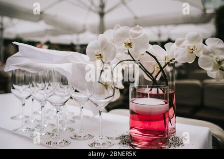 foto di un bicchiere di vino vuoto accanto a un vaso di fiori Foto Stock