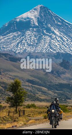 Coppia in moto da turismo. Vulcano Lanin nella parte posteriore, Argentina Foto Stock
