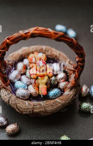 Primo piano verticale di un giocattolo bunny e Pasqua a forma di uovo caramelle in un cestino Foto Stock