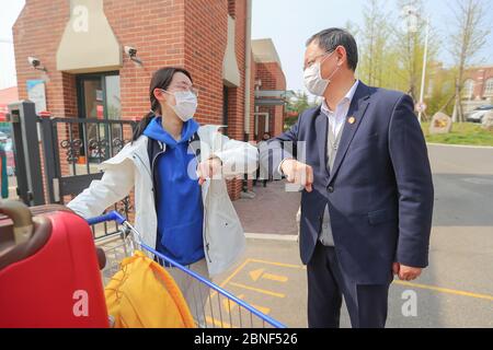 Gli studenti dell'anno superiore a Qingdao tornano a scuola e ricominciare le lezioni per la prima volta dopo il blocco. Al cancello anteriore della scuola Qingdao NO.9, Foto Stock