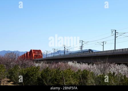 Una vista di un treno di Fuxing Hao, noto anche come la serie CR EMU, che corre sul ponte del serbatoio di Guanting della ferrovia Pechino-Hohhot, contea di Huailai, Foto Stock