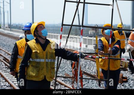 I lavoratori costruiscono la ferrovia o esaminano le strutture durante la parte Taicang della ferrovia di Shanghai-Nantong alla città di Liuhe, a livello della contea di Taicang Foto Stock