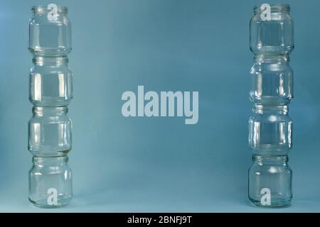Due ampie file verticali di vasi di vetro su sfondo blu. Foto Stock