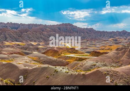 Sunbeam attraverso le nuvole di tuono al tramonto nel parco nazionale di Badlands, South Dakota, Stati Uniti d'America (USA). Foto Stock