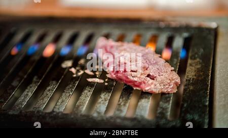 Manzo giapponese di wagyu a fette sottili sulla griglia per barbecue. Grigliate uno dei migliori manzo in Giappone. Stile Yakiniku significa cucina a base di carne alla griglia. Barbecue. Foto Stock